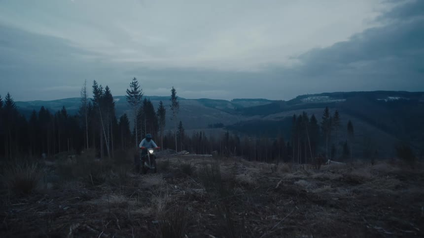 A man races his dirt bike over the hill