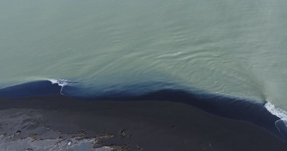 Waves breaking on the black beach