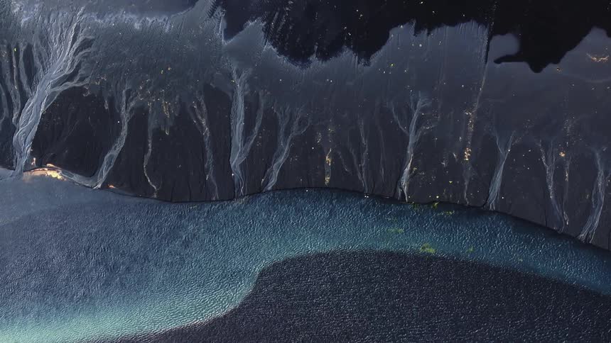 Aerial view of a river with blue water and textured shoreline