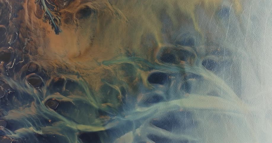 Aerial view of glacier rivers with various shades of blue and yellow colors