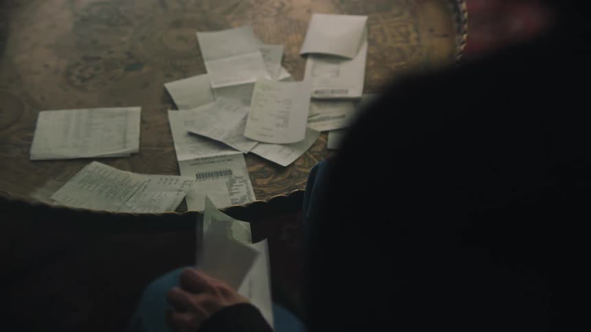 A person analyzing receipts at a table