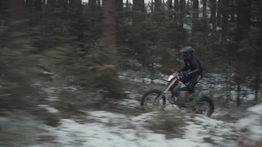 Man perform motorcycle stunts in the woods