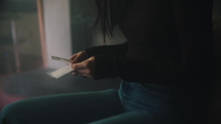 A person looking at small papers in their hands