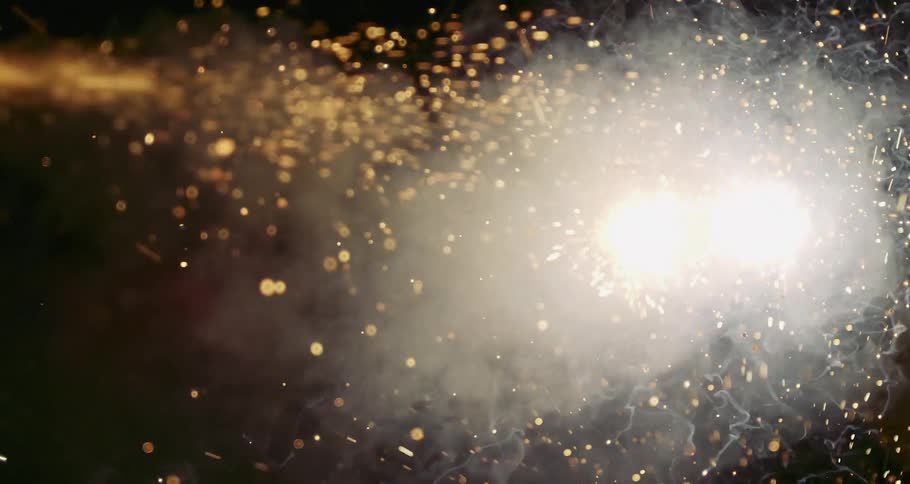 Confetti and fireworks display in the sky at night