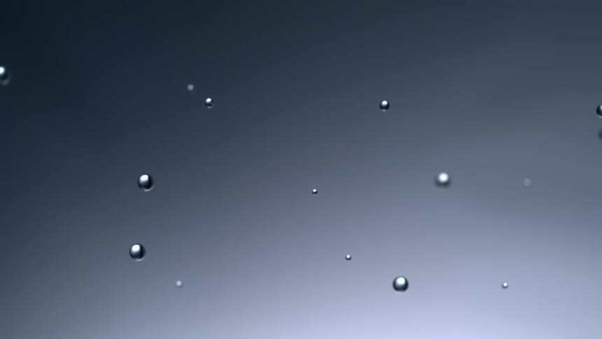 Water drops cling to moving gray surface