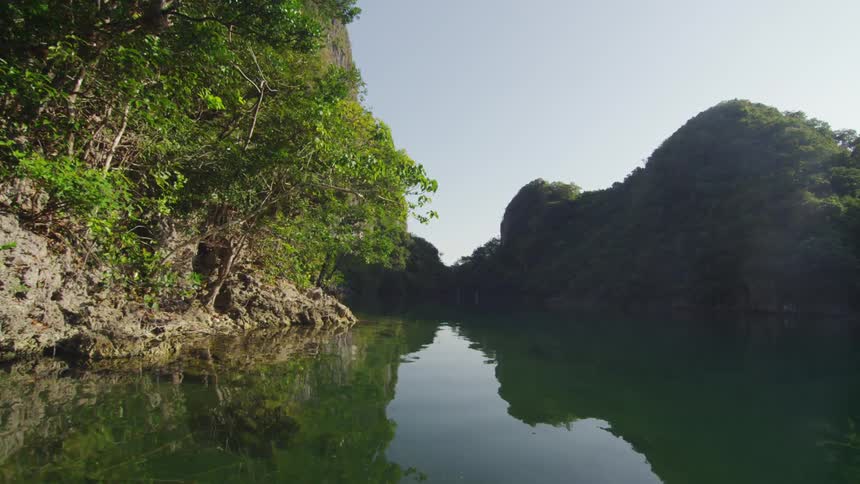 A river lined with trees and rock formation
