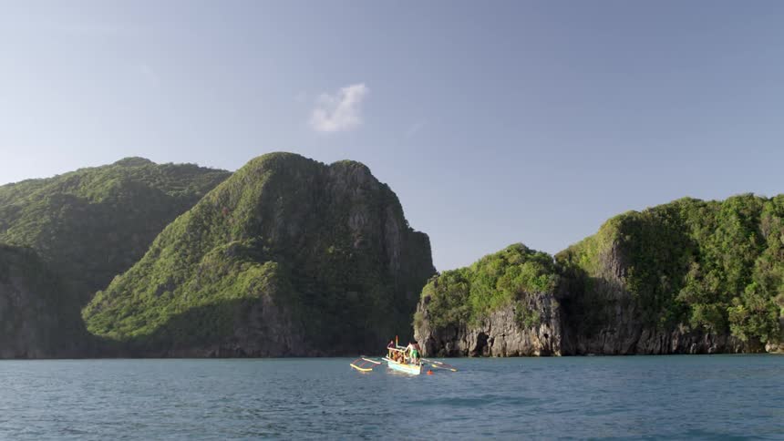 A boat is sailing towards some mountains