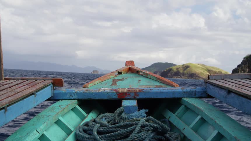 A boat floating on a body of water on a cloudy day