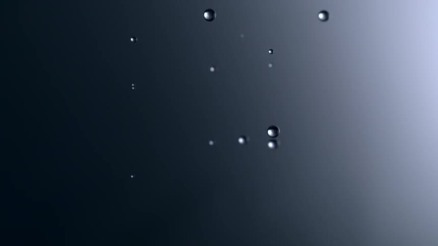Water droplets fall against a gray background