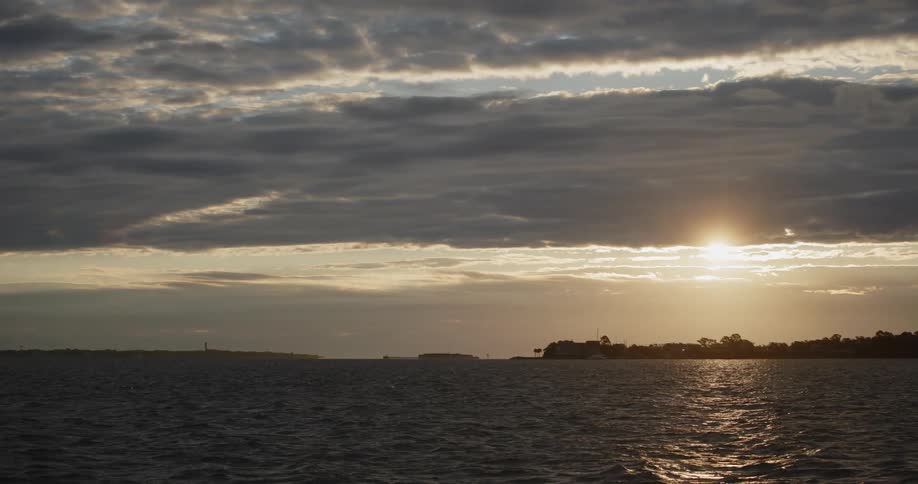 Panorama of the sea with its gentle waves and the sunrise sun in slow motion