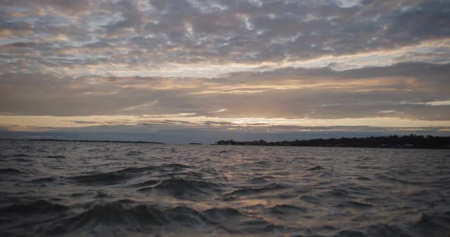 The sun is setting on the ocean