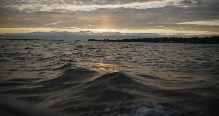 The sun is rising on the shore
