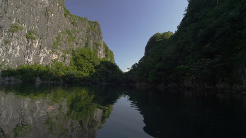 A body of water between mountains on a sunny day