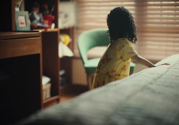 A child is standing near the bed