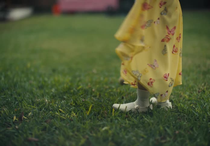 Closeup on the legs of a young girl spinning on the grass