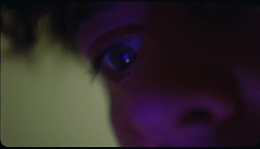 Right eyeball of someone looking at a mobile screen indoor
