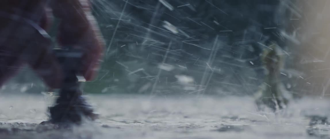 A human hand moving a chess piece on a floor that is being wet by rain