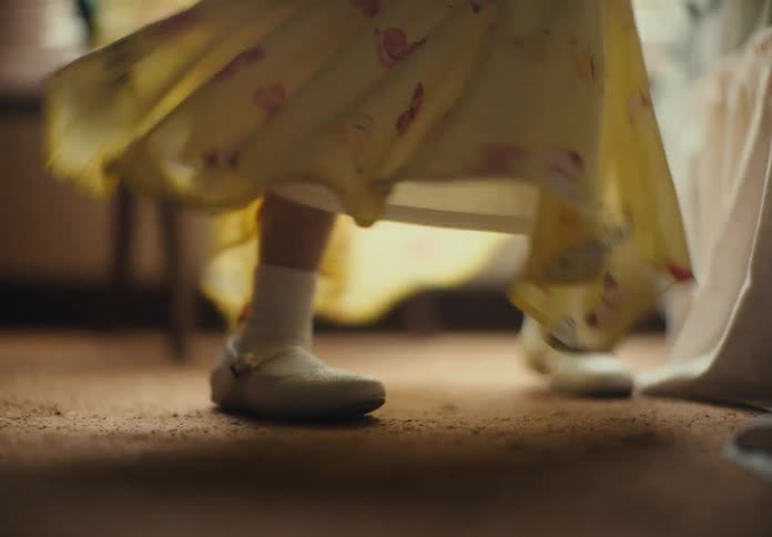Closeup of a young girls feet spinning in her yellow dress