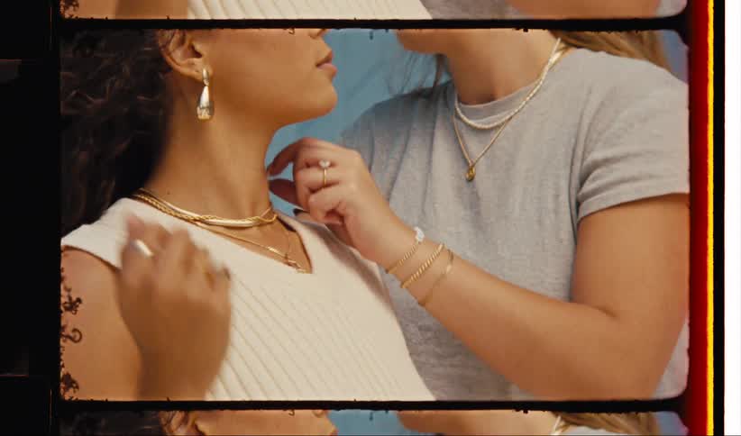 Woman adjusting a necklace around the neck of a model