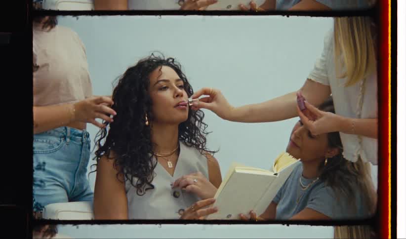 Women doing makeup and styling the hair of a model