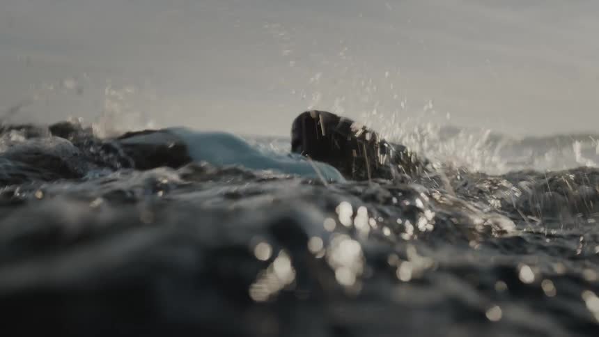 Two men swimming in a sea with goggles during the day