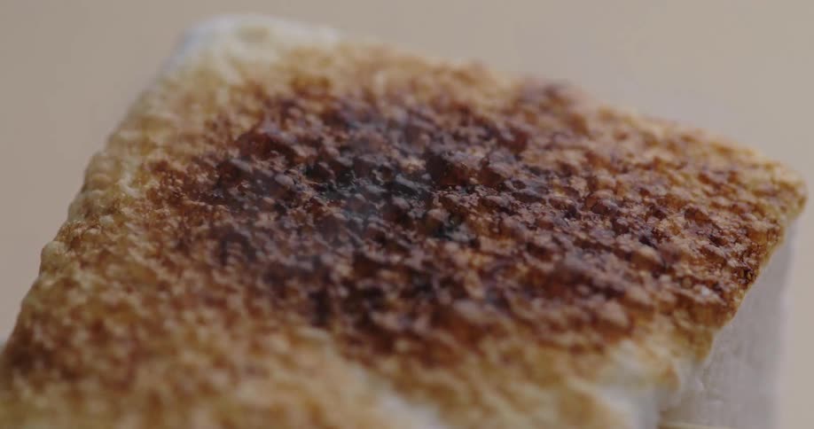 The surface of a white dessert burning and making some bubbles until it turns black