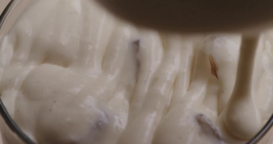 Creamy liquid being poured onto a dessert