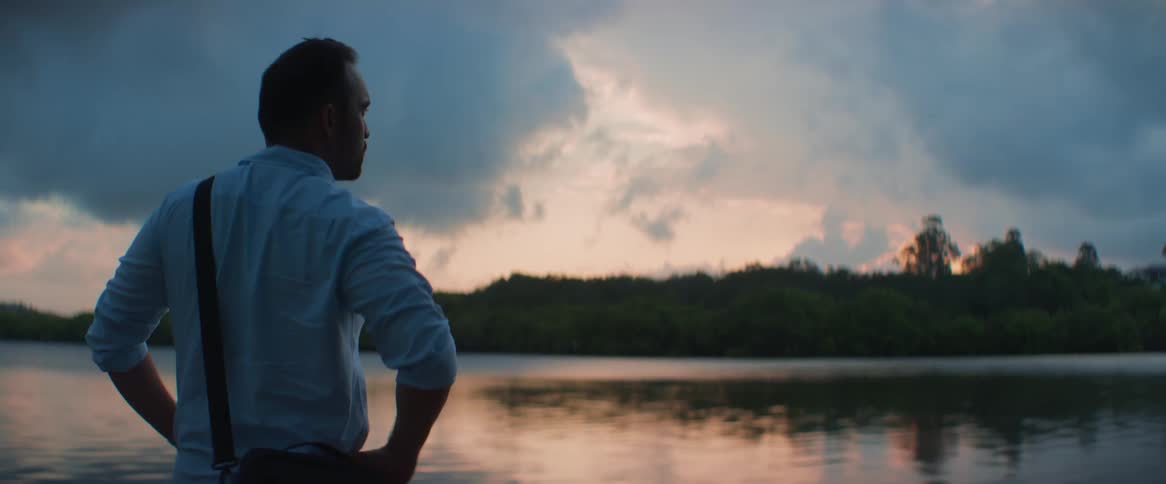 A man standing by the river bank contemplating