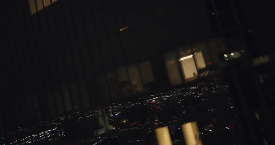 Glass skyscraper in the midst of a nighttime metropolis