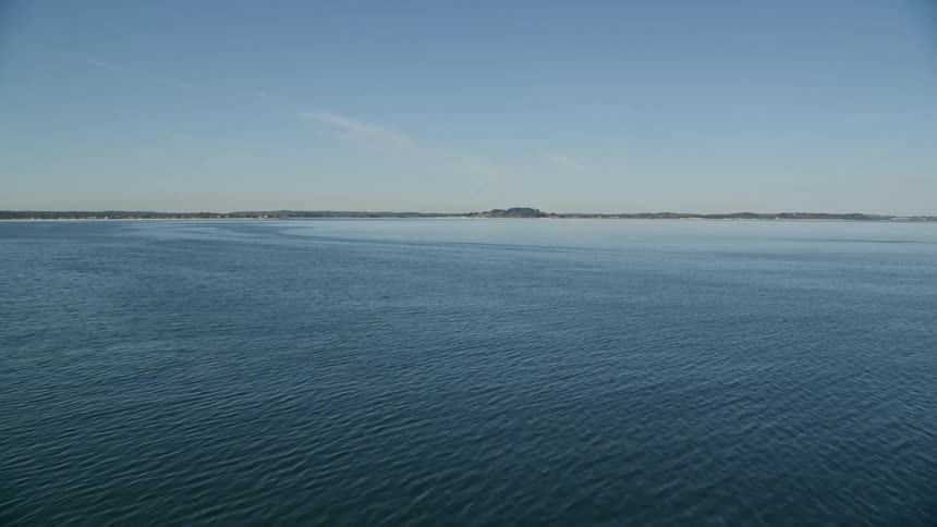 A huge blue ocean with a land in the background