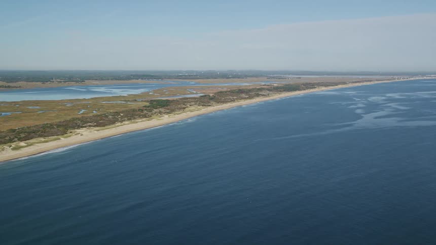 An aerial view of a land that faces the blue ocean