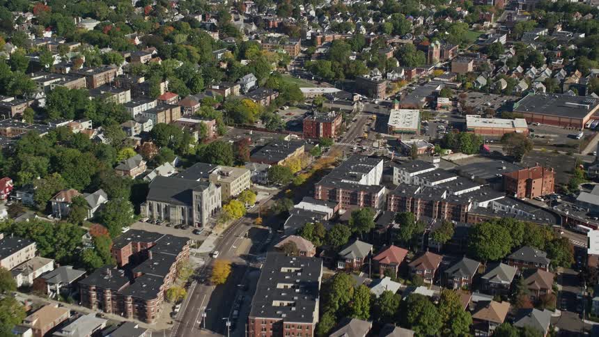 An aerial view of a city with several houses and many green trees