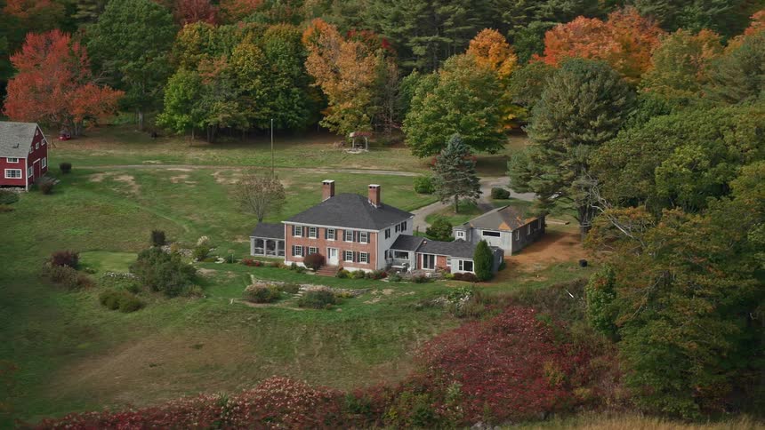 An aerial view of two country houses closer to the lake
