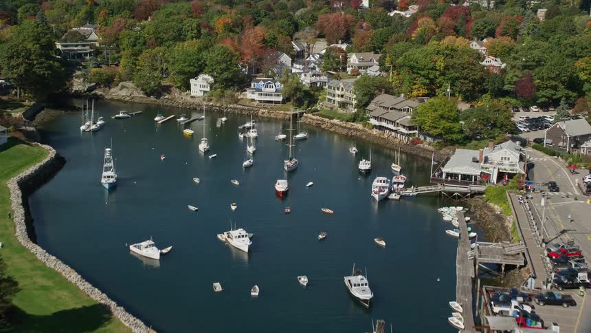 A coastal residential area with a river that runs through the city and is full of boats above
