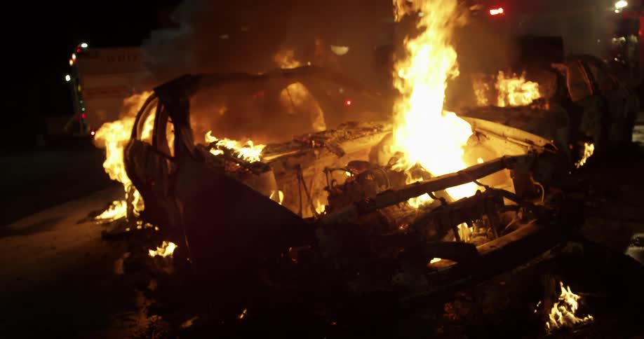 A car is engulfed in flames at night