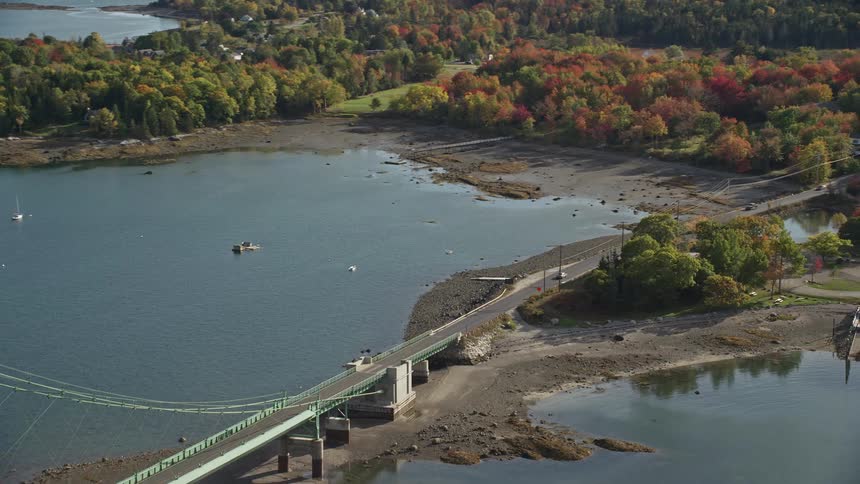 Aerial view of vehicles driving on a suspension bridge over a river