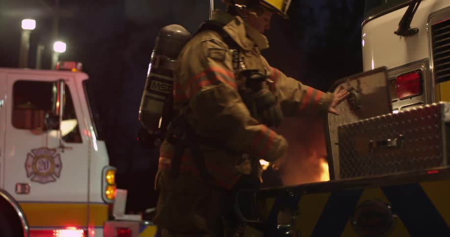 Fireman walk over to their truck at night