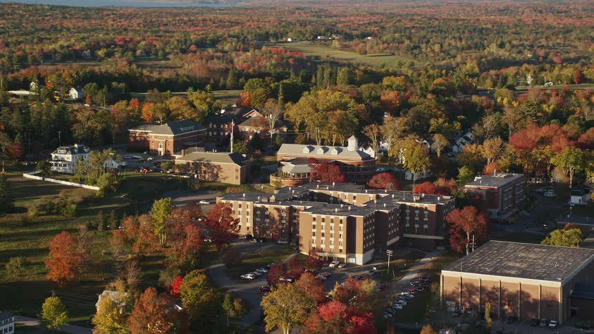 View of an urban city amidst green fields with autumn trees