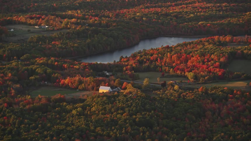 Aerial panorama of small houses amidst forests a highway and lakes