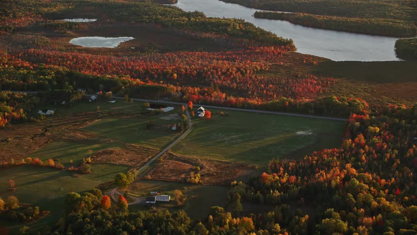 Aerial view of houses on a field in the countryside next to a lake