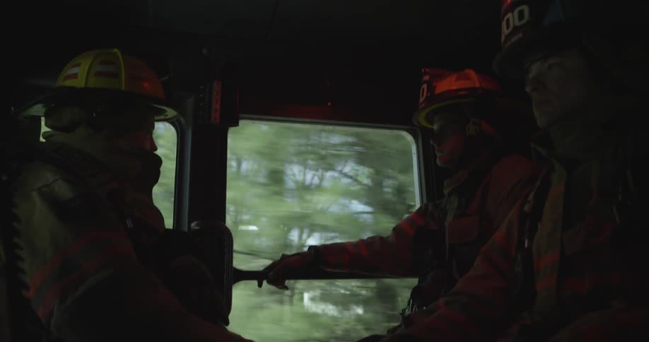 Firefighters are riding in a fire truck
