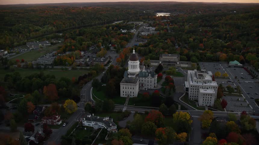 Aerial view of building with domed spire in neighborhood with fall colors