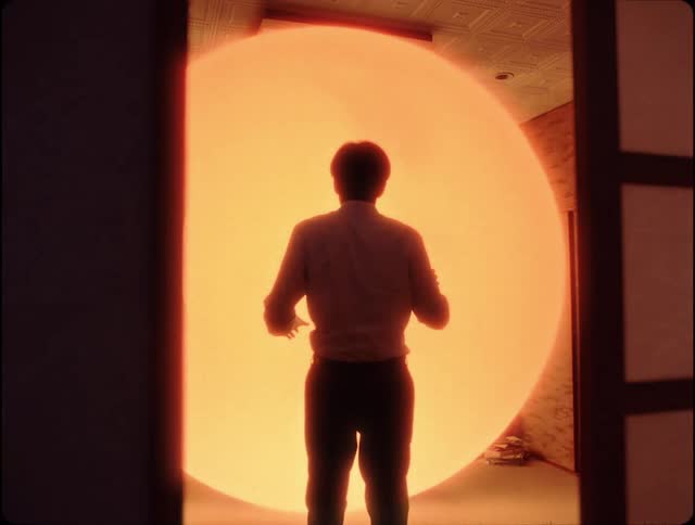 Man facing a large abstract and colorful ball that changes to warm colors