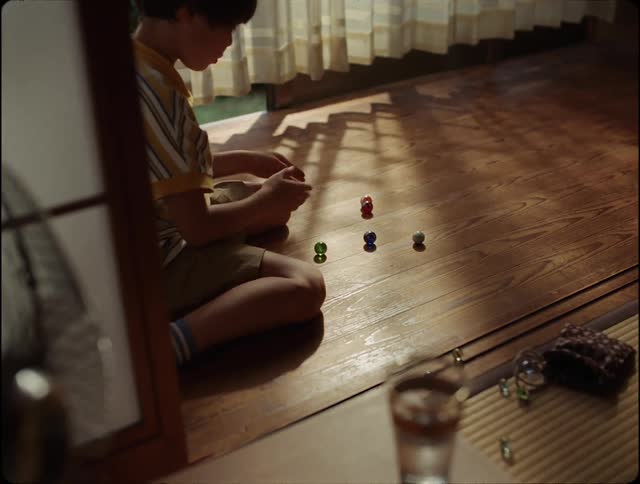 Child sitting and playing marbles alone