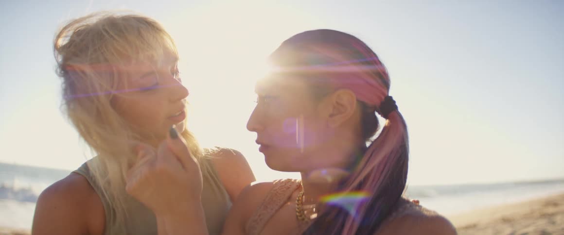 Portrait of two women dancing with their hands on the beach