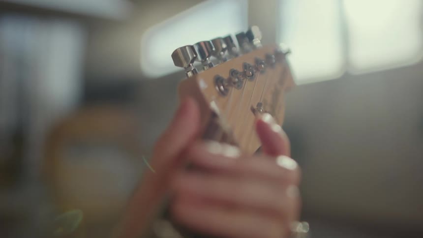 A person tuning the strings of a guitar