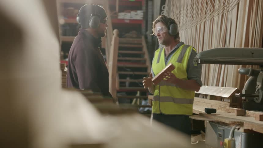 Two workers are talking in the lumber yard