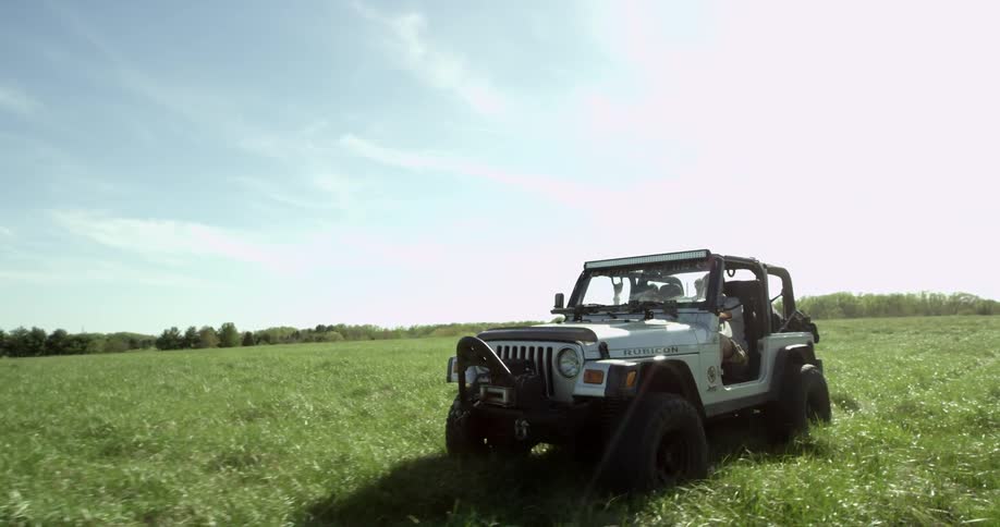 A jeep crosses an open field