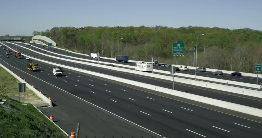 Cars are traveling on the highway on a sunny day