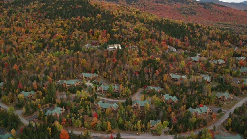 An aerial panorama of a residential neighborhood next to mountains rich in vegetation and trees